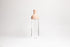 Tall glass container with light pink rubber wine bottle shaped top on an white backdrop.